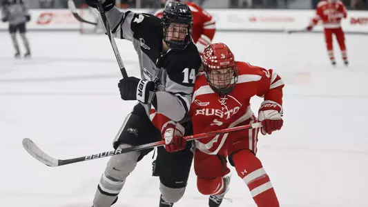 MIH - Aleksi Kivioja battles against BU player for the puck