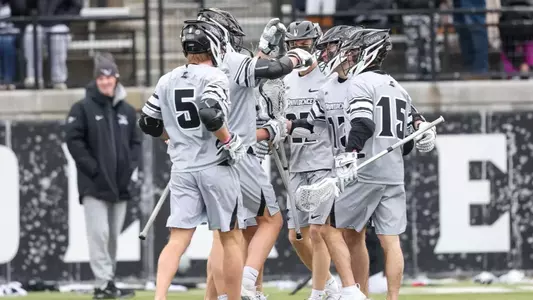 Lacrosse group celebration after scoring a goal versus Loyola Maryland.