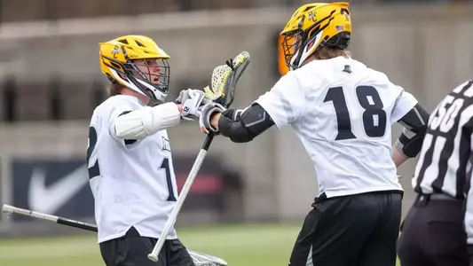 Lacrosse players Ben Dale and Jack Horrigan fist bumping after a goal against Villanova