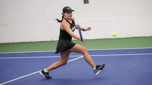 Tennis player Elisa Davalos goes to hit a ball during an indoor match.