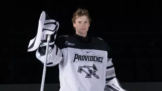 Providence College Men's Hockey player Aaron Matthews standing with his stick in his hand during a media day shoot at Schneider Arena in 2025.