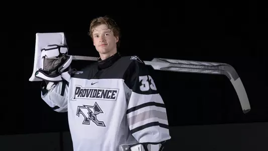 Providence College Men's Hockey player Aaron Matthews poses with his stick over his back during a media day shoot at Schneider Arena in 2025.