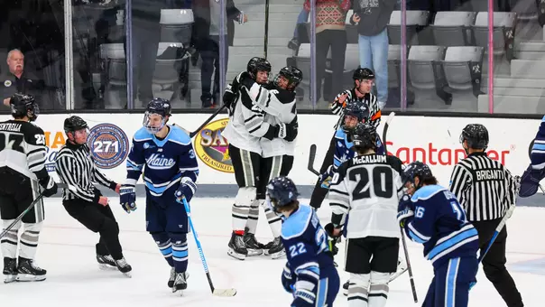 Men's Hockey celebrates a goal vs Maine featuring Roger McQueen, Julius Sumpf and Kale McCallum