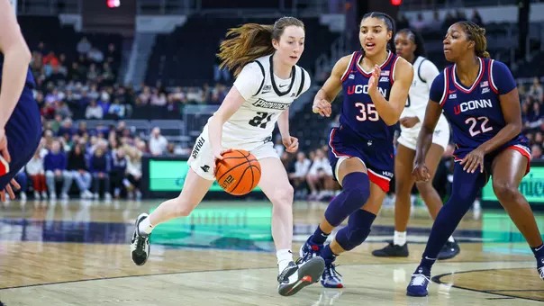 Payton Dunbar dribbles the ball by a Connecticut defender.