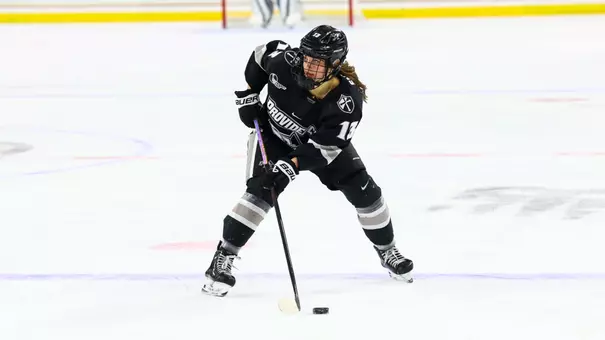 Women's ice hockey player Sami Snyder skating with the puck during a game against Boston College