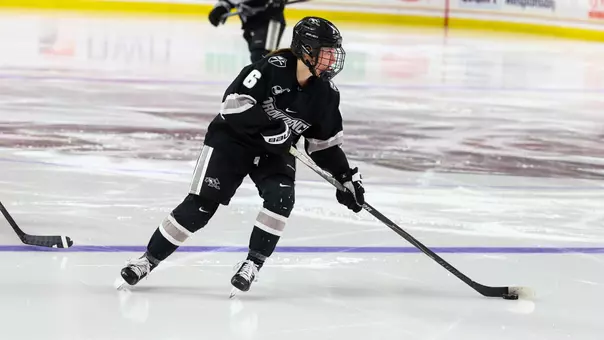 Women's ice hockey player Audrey Knapp skating with the puck during a game against Boston College