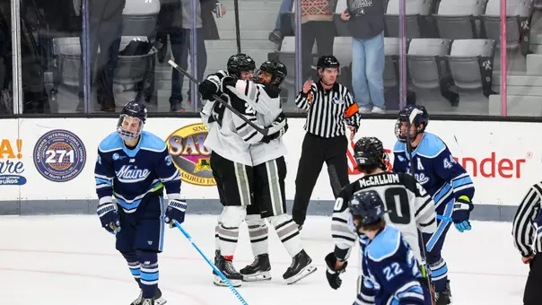 Men's hockey players Roger McQueen and Julius Sumpf celebrate a goal against Maine