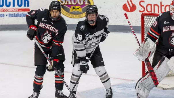 Men's hockey's Tanner Adams fights for position against Northeastern