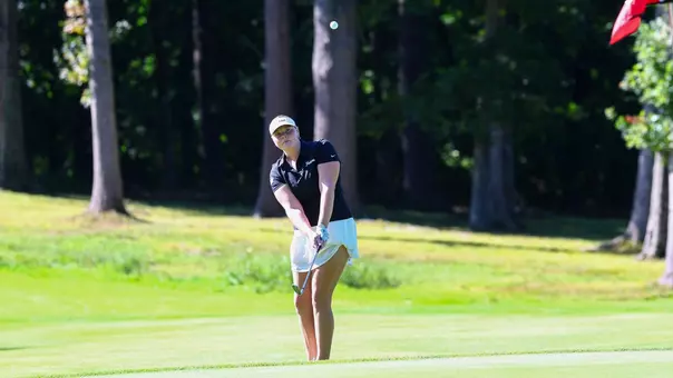Women's golfer Myla Bisceglia hitting a chip shot onto the green