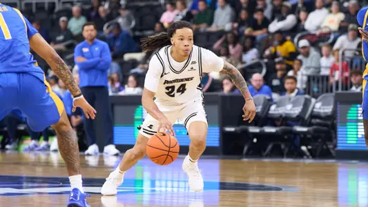 Men's basketball player Malik Mack dribbling during a game