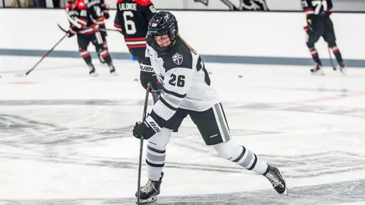 Cameryn Shiels skating on ice hitting puck