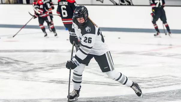 Cameryn Shiels skating on ice hitting puck