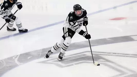 Will Elger skates with the puck in a game against UConn