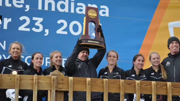Director of Cross Country and Track Ray Treacy lifting the Cross Country National Championship trophy