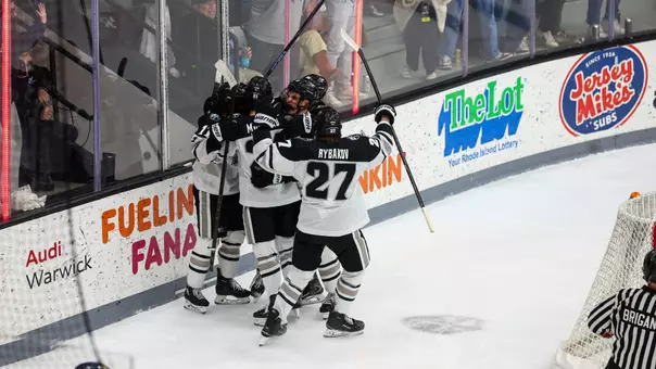 The men's ice hockey team celebrating together after scoring a goal