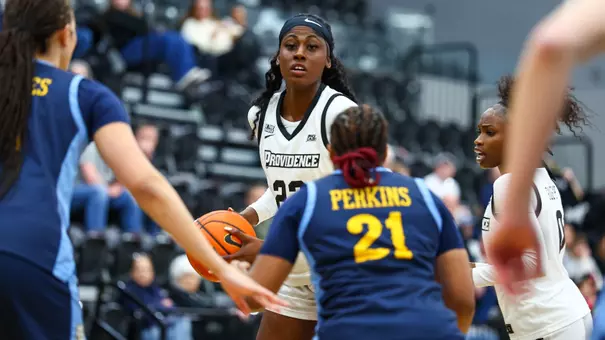 Eseosa Imafidon dribbles the ball with her right hand while being defended by a player from Marquette.