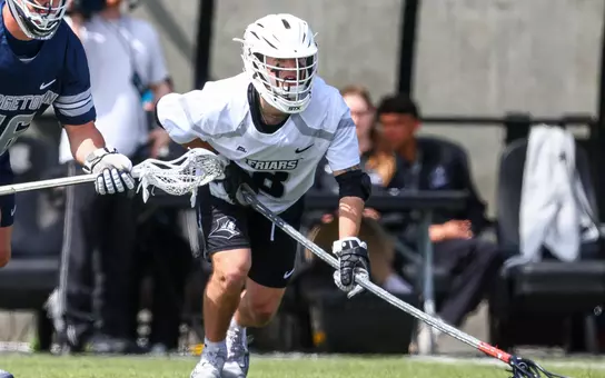 Ian Olenik leans in before a faceoff in white jersey with white helmet and black shorts vs Georgetown at Chapey Field at Anderson Stadium.