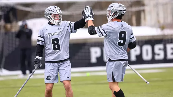 Ian Olenik high fives Richie Joseph during a lacrosse game at Chapey Field at Anderson Stadium.