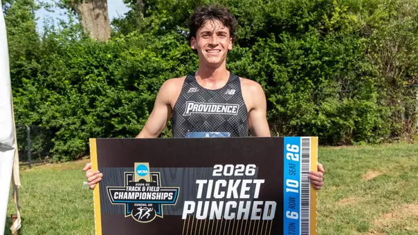 Men's track runner Elliott Pugh with the Ticket Punched sign for NCAA Outdoor Track Championships