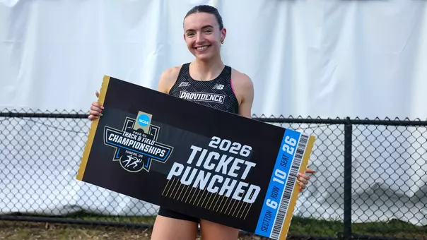 Maeve O'Neill holding a sign that reads "2026 Ticket Punched" on an oversized ticket with the NCAA Division 1 Track and Field Championships logo
