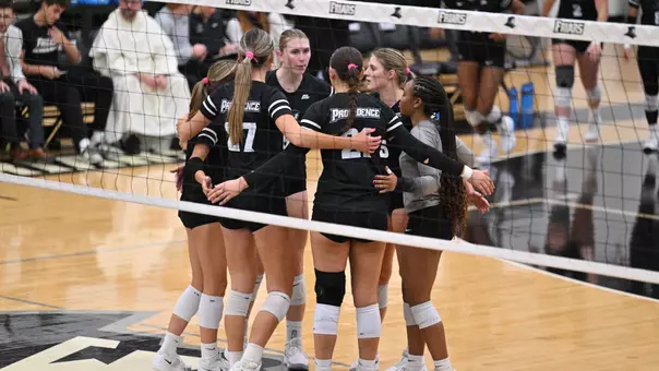 Volleyball huddle during a match against Xavier
