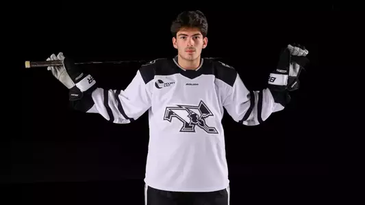 JJ Monteiro Men's Hockey with stick over the shoulders