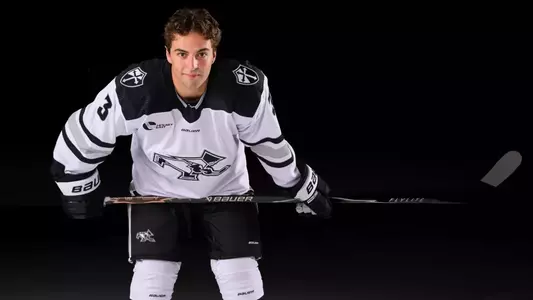 Jack Laferriere Men's Hockey leaning down on stick