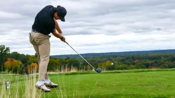 Men's golf player Callan Fahey hitting a tee shot at the UConn Invitational at GreatHorse