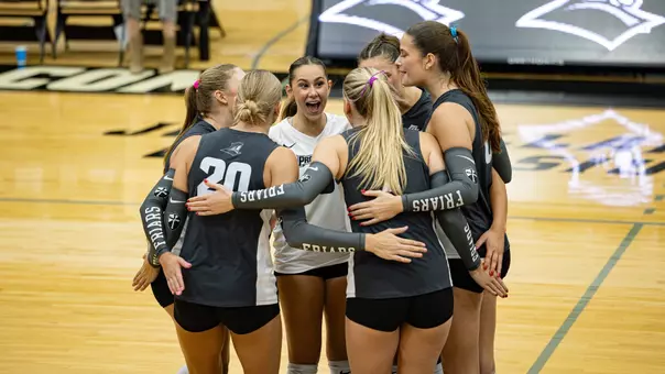 Providence Volleyball in a huddle after a point against DePaul