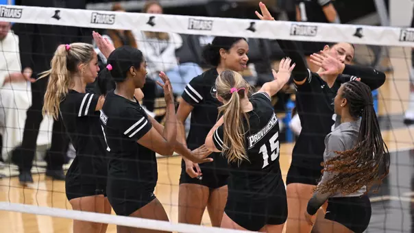 Volleyball celebrates a point in a group huddle