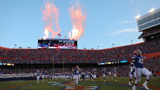 Football team takes field, fireworks errupt from the videoboard