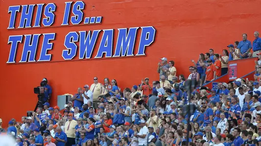 Gators Fans in front of the This Is The Swamp sign