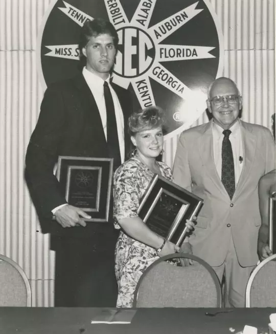 Alec Kessler (Georgia basketball) and Janice Kerr (Florida gymnastics) receive the 1990 SEC Scholar-Athlete Award from Southeastern Conference Commissioner Roy Kramer