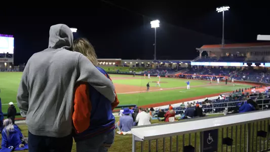 A couple watches the Florida - Miami baseball game from the berm during opening night at the new Florida Ballpark