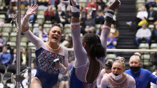Savannah Schoenherr cheers Trinity Thomas' uneven bars 2202-4
