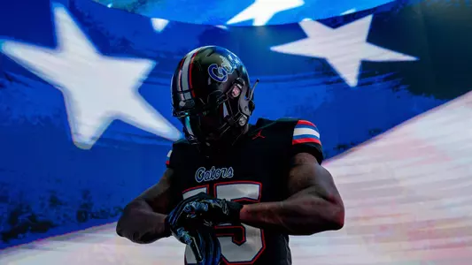 United States flag waves behind athlete wearing black Gators uniform