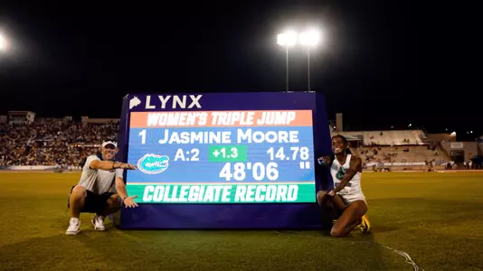 Jasmine Moore and Coach Nic Peterson with the collegiate record board