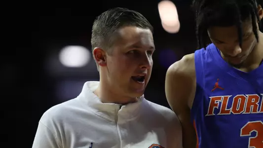 Kevin Olsen talks to Alex Fudge during a men's basketball game.