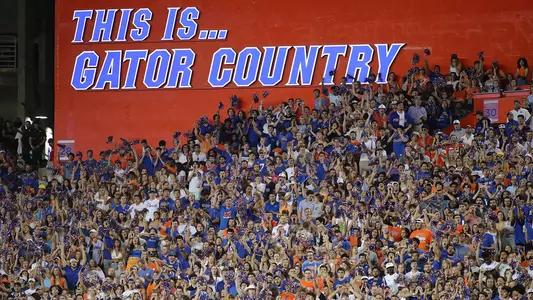 Cheering fans in front of the This Is Gator Country sign in The Swamp