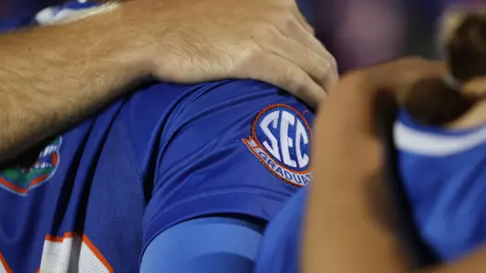 Team huddle with SEC Graduate patch