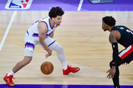 Walter Clayton Jr. dribbles in a Jazz uniform against a Portland defender during an NBA preseason game.