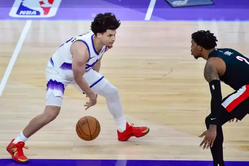 Walter Clayton Jr. dribbles in a Jazz uniform against a Portland defender during an NBA preseason game.