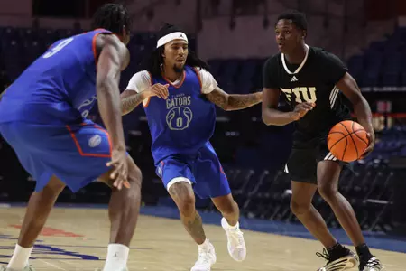Boogie Fland defends an FIU player at Florida's men's basketball scrimmage, with Rueben Chinyelu providing help defense.