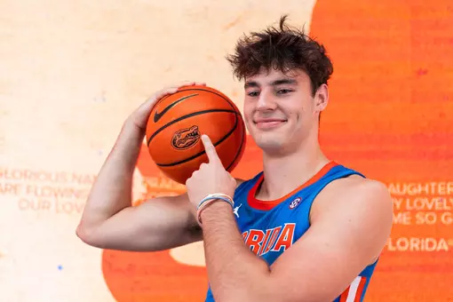 New men's basketball signee Jones Lay points to the Gator logo on the basketball while wearing a Florida jersey.