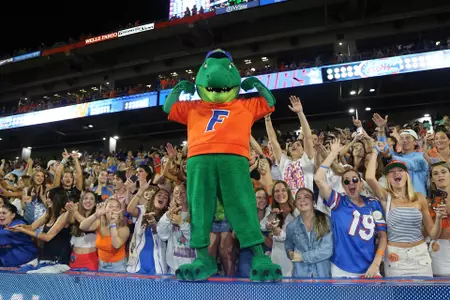 Albert mascot stands on stadium wall and cheers with fans