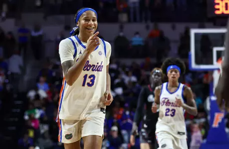 Laila Reynolds laughing, pointing at Gators bench against
