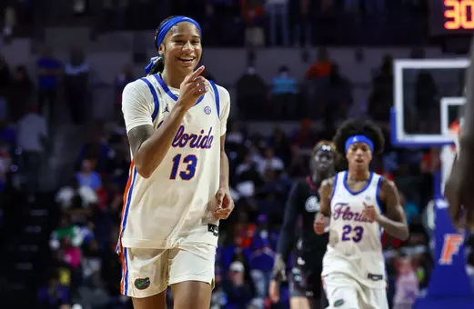 Laila Reynolds laughing, pointing at Gators bench against
