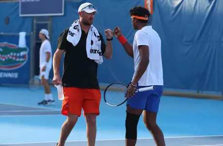 Adhithya Ganesan giving a fist bump to Assistant Coach Max Koller following a point in the singles match.