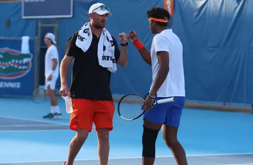 Adhithya Ganesan giving a fist bump to Assistant Coach Max Koller following a point in the singles match.