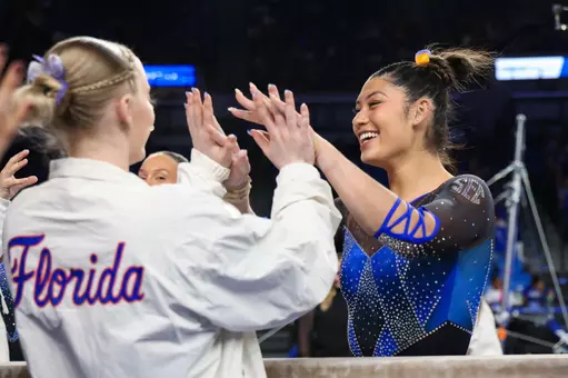 Kayla DiCello high-fives Lori Brubach after her balance beam routine 260313